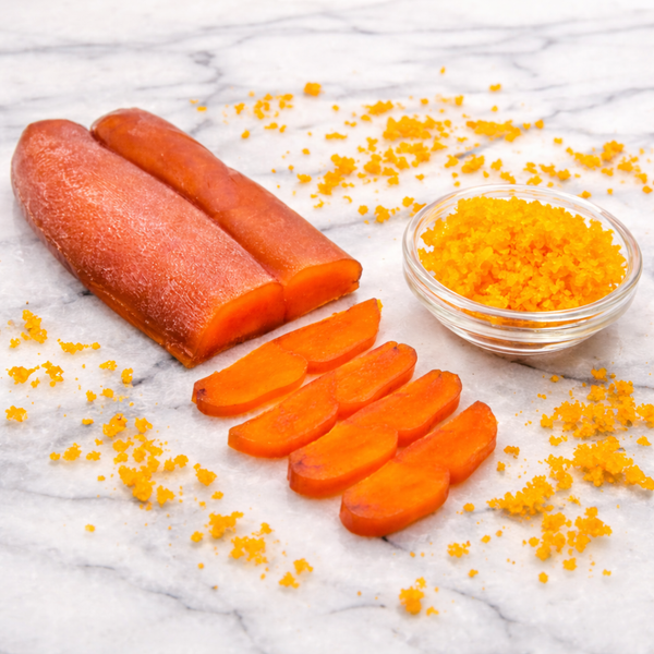 A whole pressed lobe of bottarga alongside thin amber slices